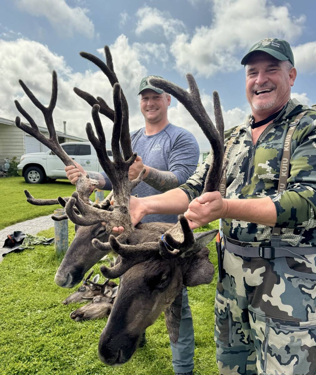 Two hunters with a pair of trophy Caribou racks