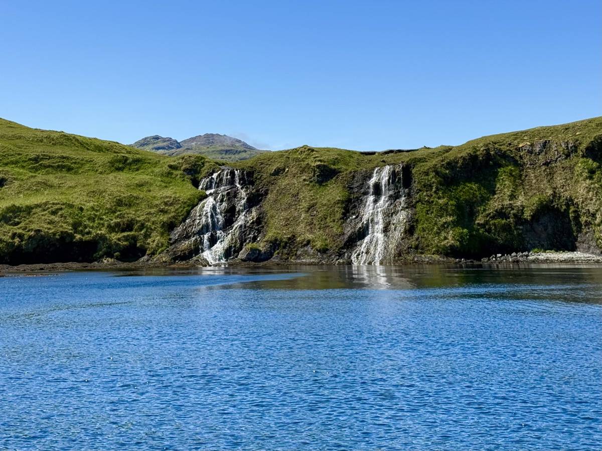 Twin waterfalls dropping into an Adak cove